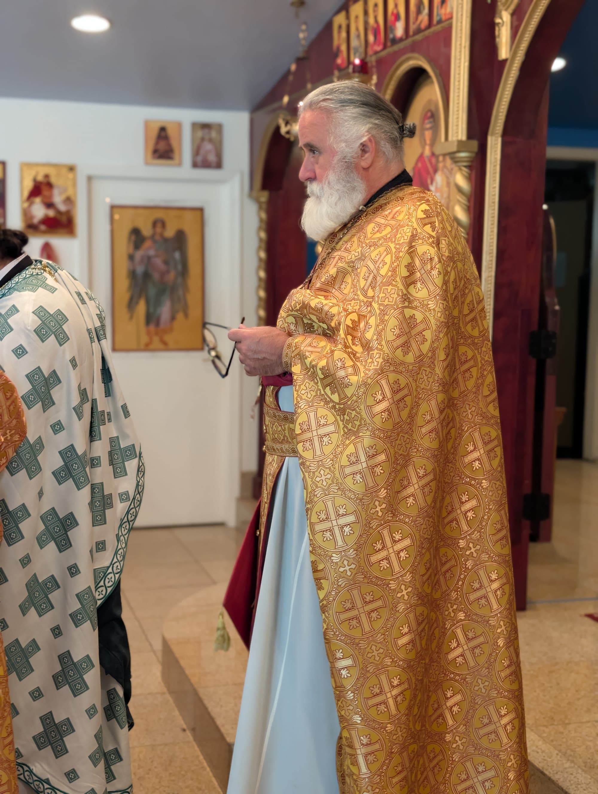 Fr. Romanos Khoury in gold vestments before the iconostasis