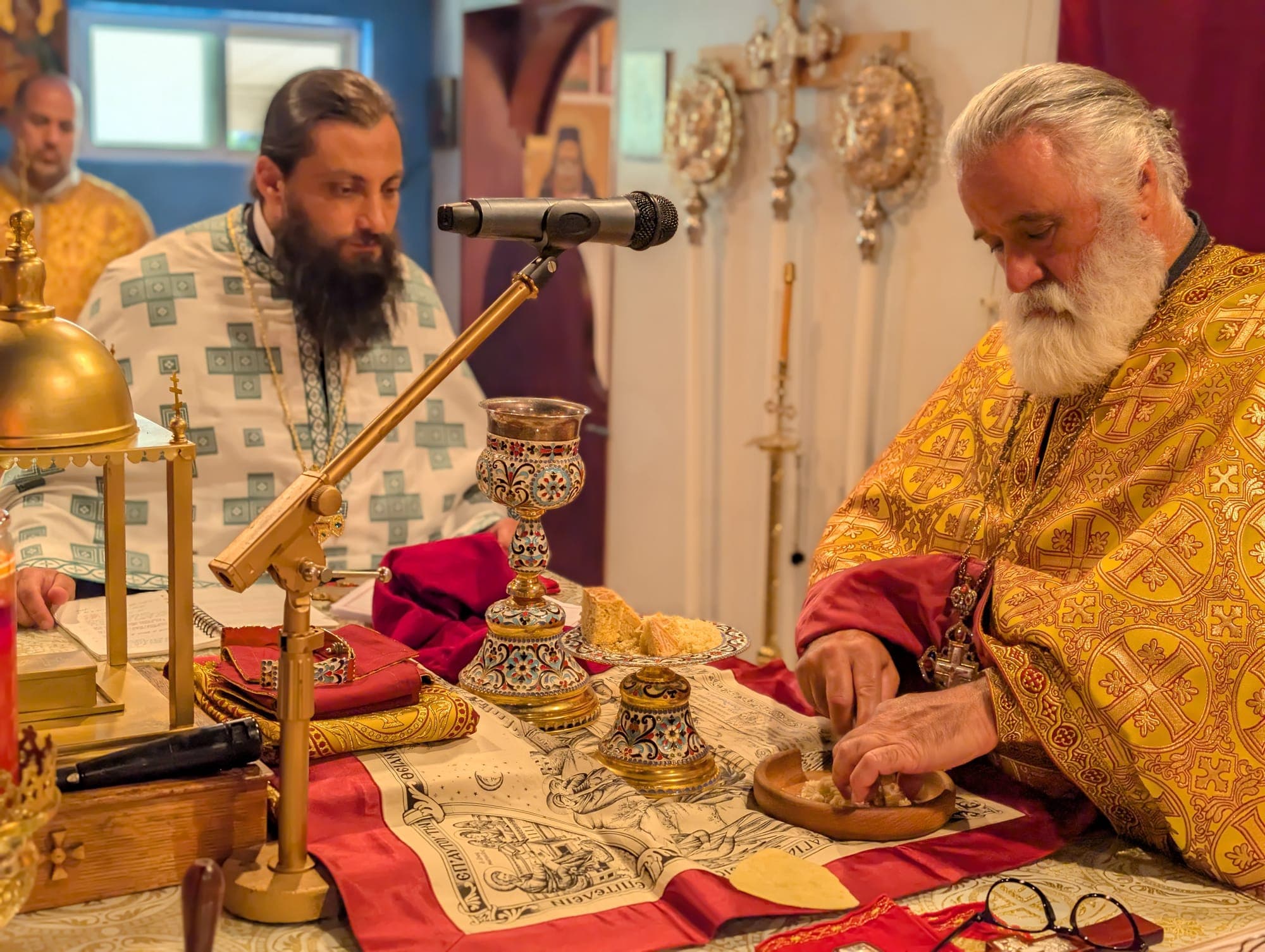 The priest preparing the Holy Gifts at the altar