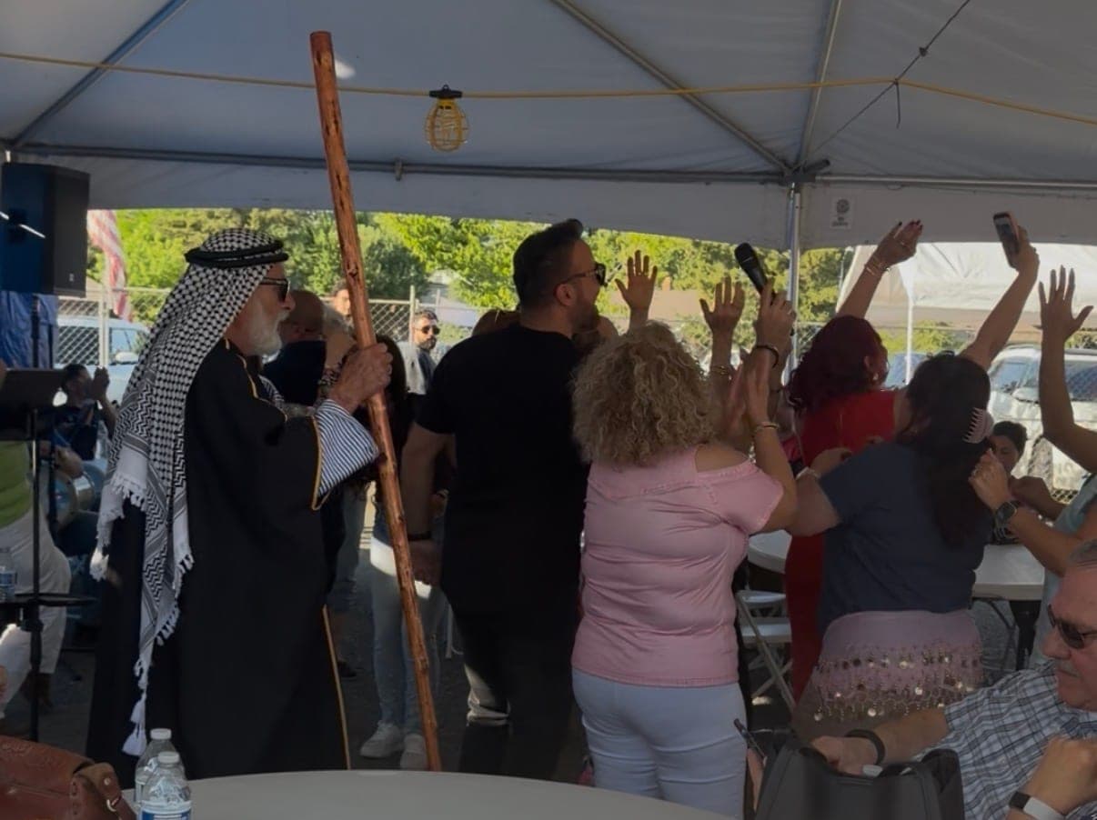 Dancers with hands raised behind the dabke leader