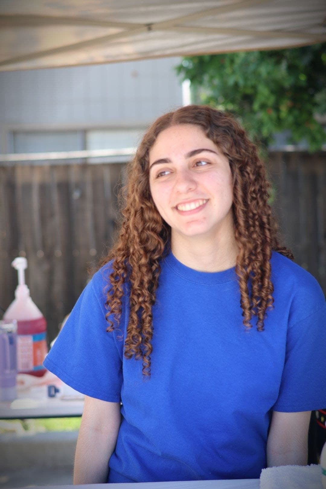 A volunteer smiling at a festival booth